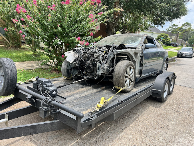 A car is on the back of a flatbed trailer